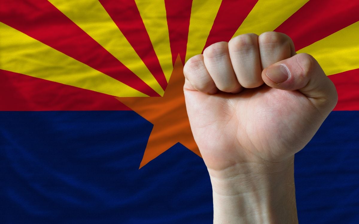Us state flag of Arizona with hard fist in front.
