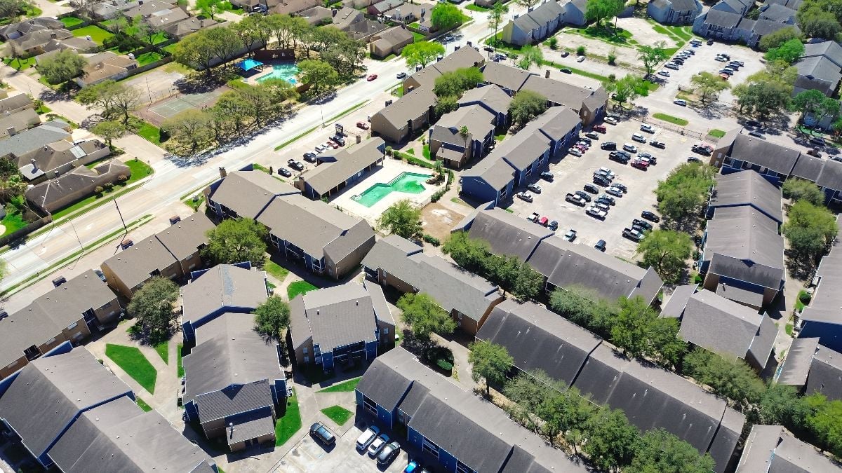 Multistory apartment complex buildings and suburban residential houses.