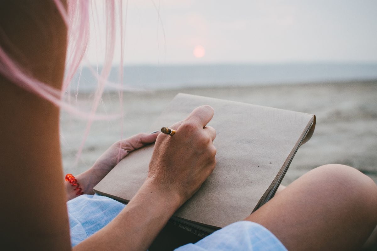 Woman journaling at sunrise.