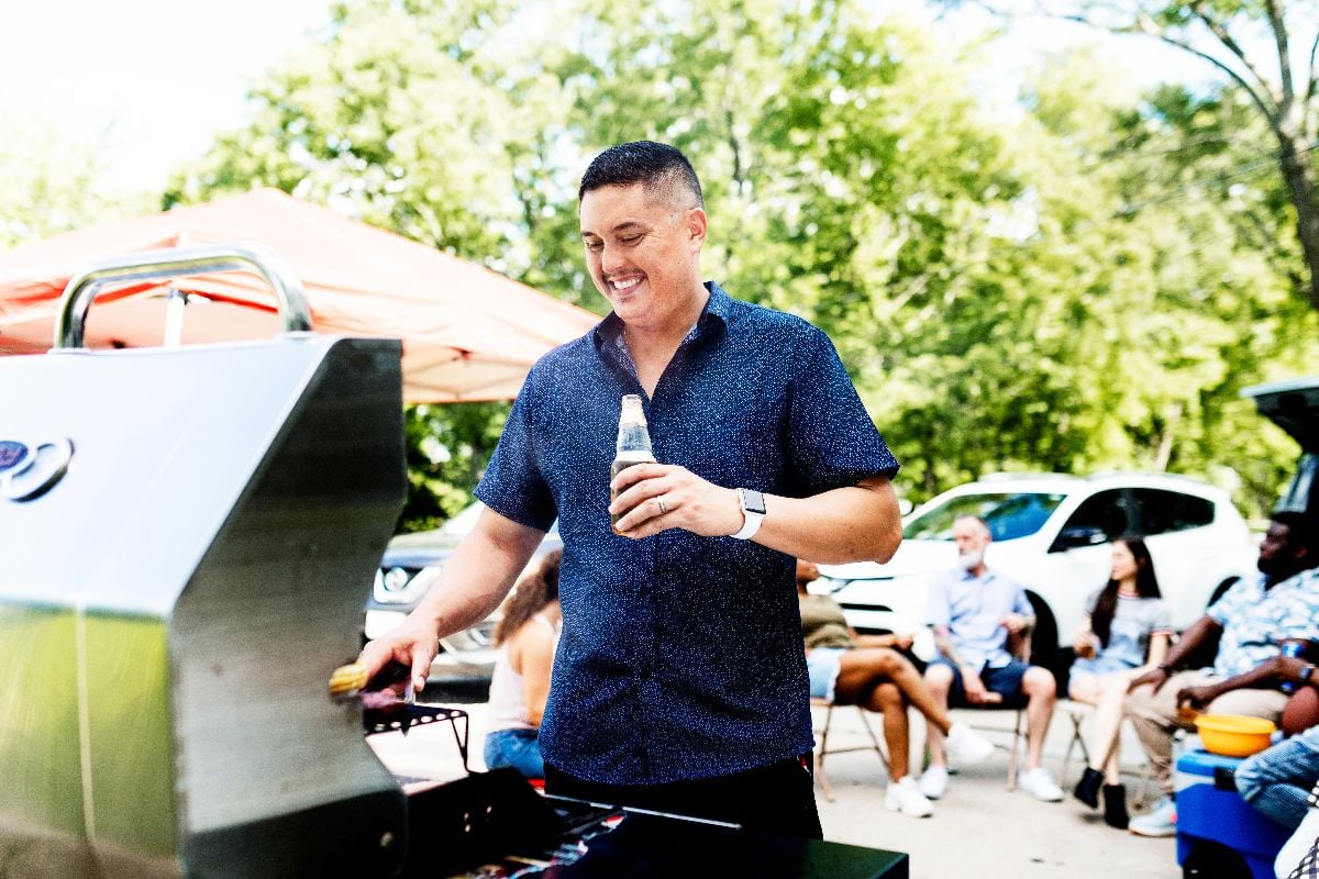 Manning the grill at a tailgate party.