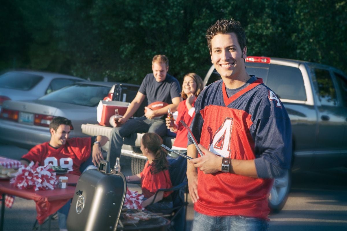 Group of friends at a football tailgating party outside.