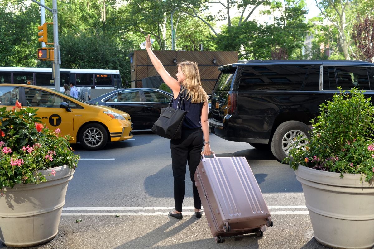 Woman catches a taxi at the street in New York.