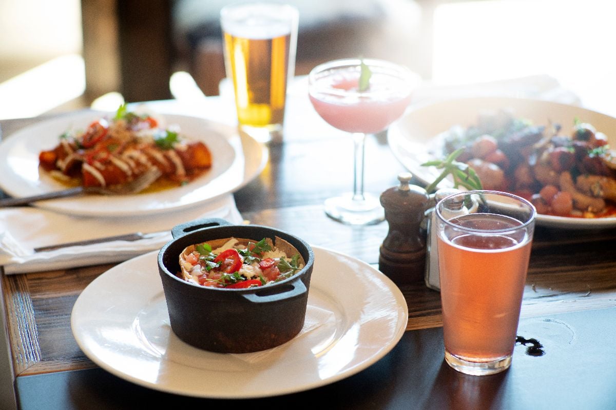 Entrees and drinks on a table in a restaurant.