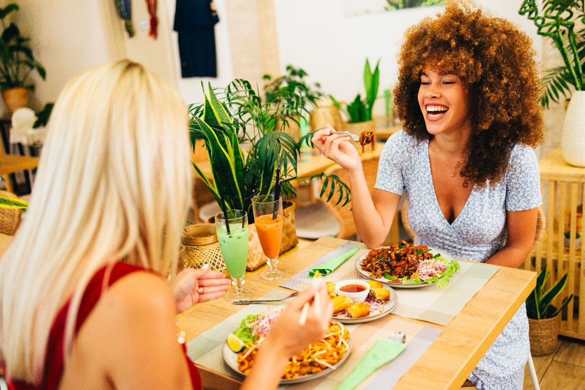 Two cheerful women enjoying a meal in a Thai restaurant.