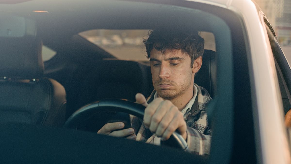 Man inside car using mobile phone while waiting in traffic jam.
