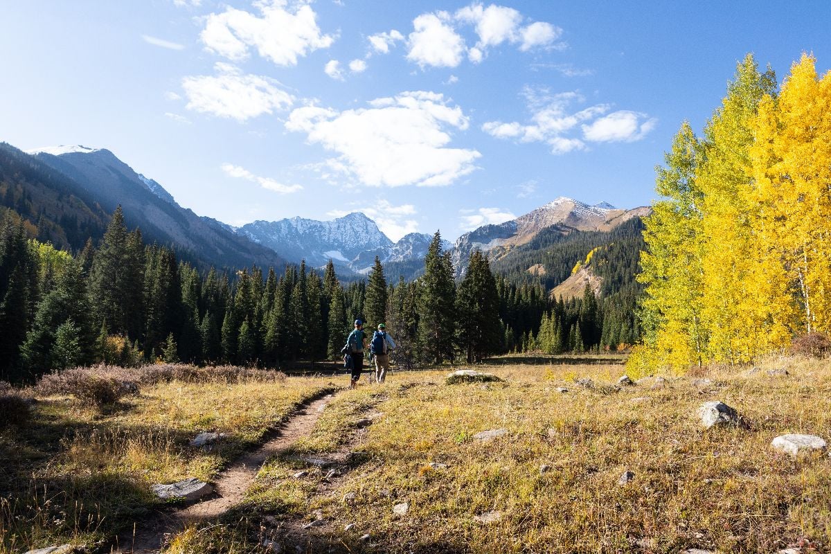 Hikers walking through the prairie portion of Capitol Ditch Trail near Aspen, Colorado.