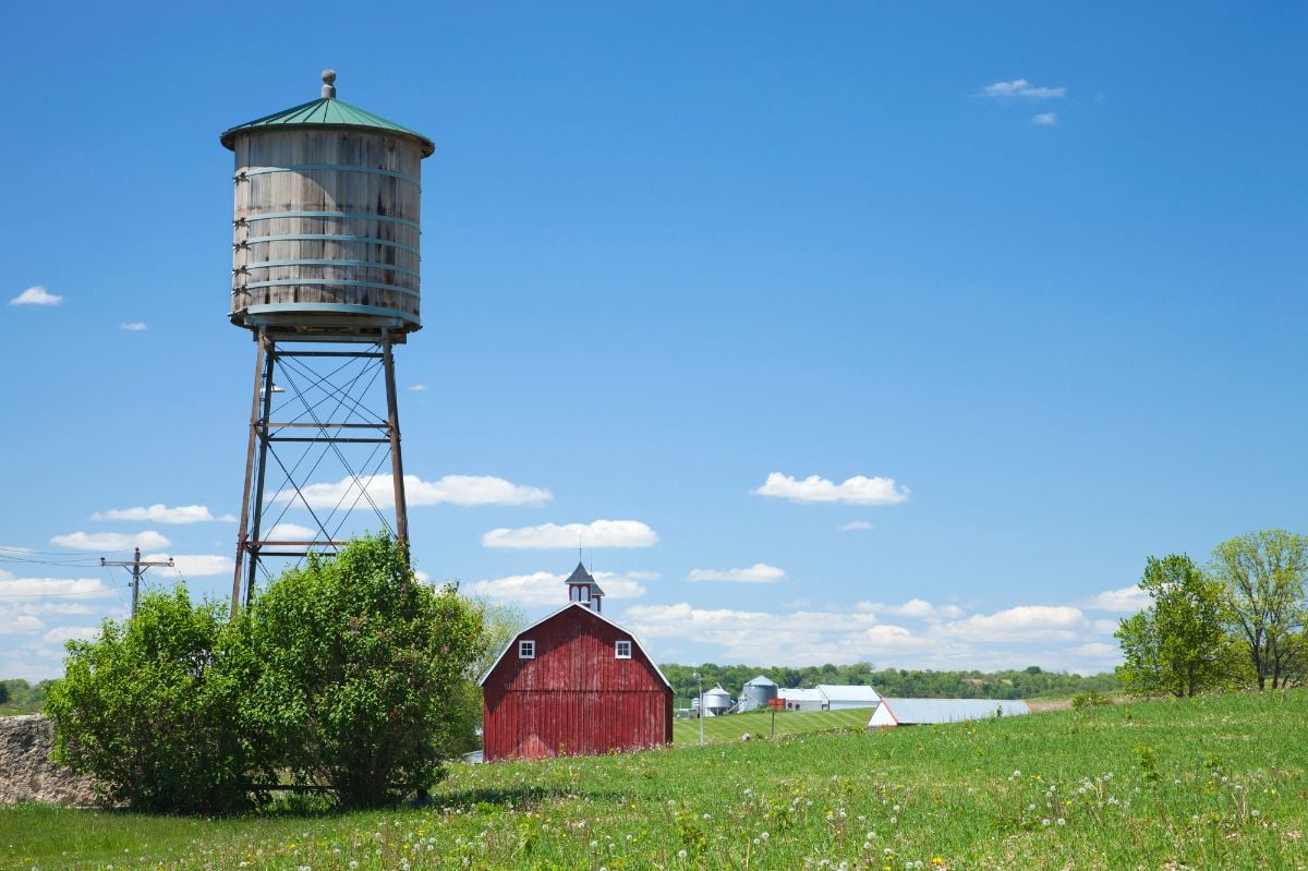 Old water cistern and red barn in rural Iowa.