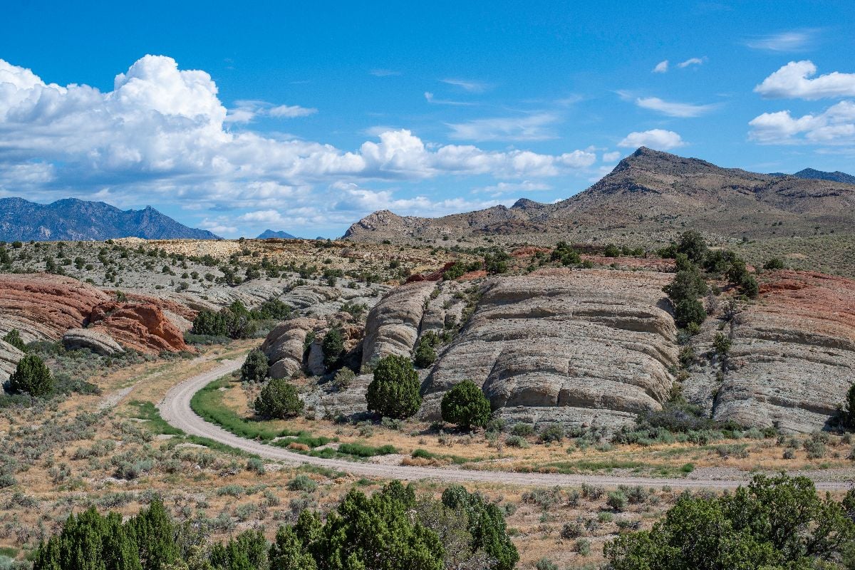 dirt road curves around volcanic tuff rocks.