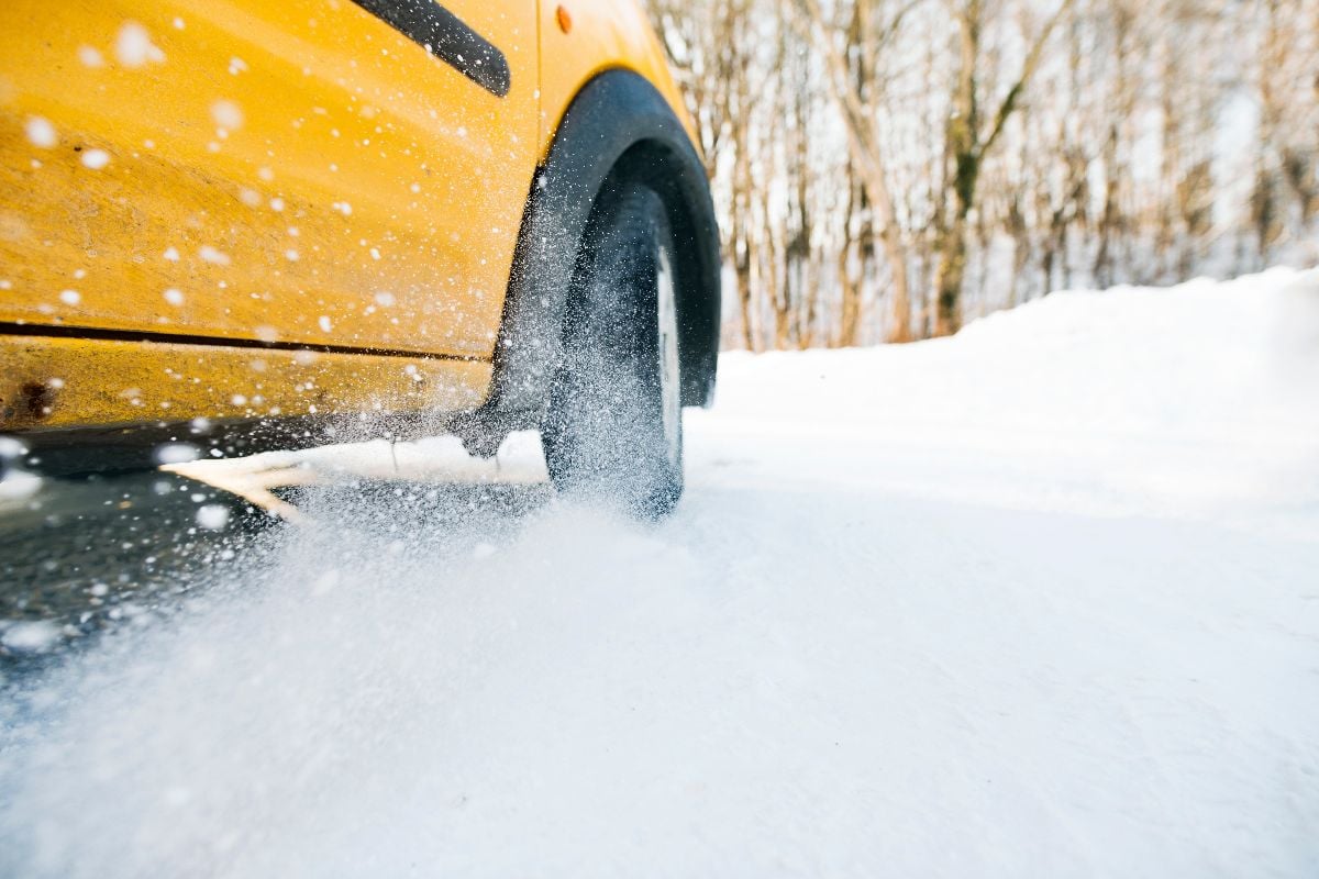Close-up of a car wheel skidding on a frozen, icy road.