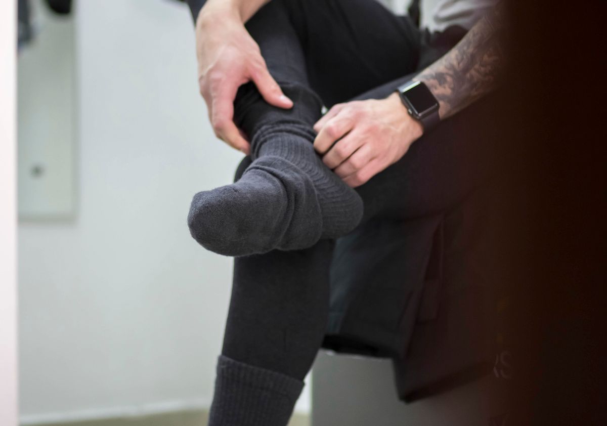 A man puts on warm winter socks.