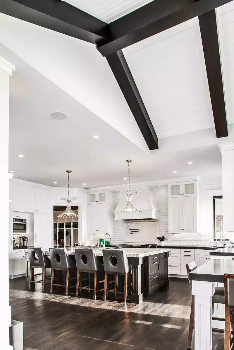 Vaulted Ceiling Kitchen with Dark Wood Beams and Crystal Chandeliers