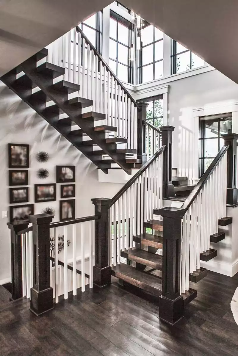 Multi-Level Floating Staircase with Vertical White Balusters and Skylight