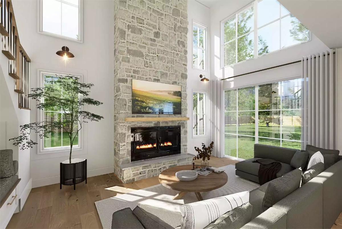 Floor-to-Ceiling Stone Fireplace Anchors a Two-Story Volume Without Shrinking
