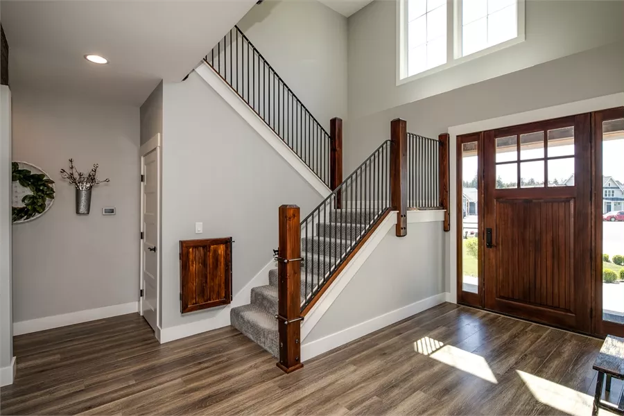 Two-Story Foyer with Dark Wood Staircase and Custom Entry Door