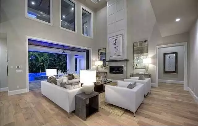Double-Height Living Room Opens to Pool Through Floor-to-Ceiling Glass