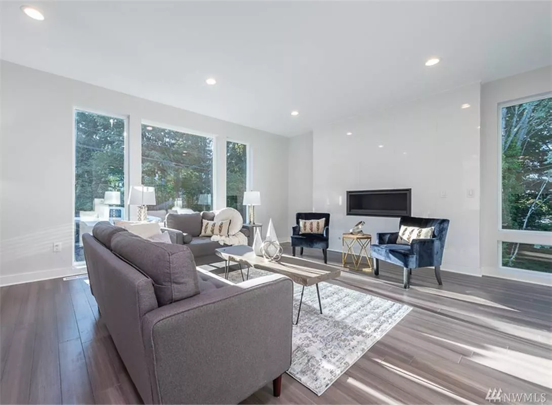 Gray Sofas and Navy Accent Chairs Frame a Fireplace That Anchors the Room