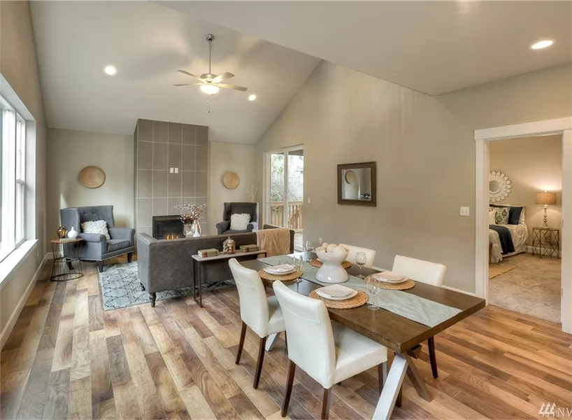 Open-Concept Living and Dining Area with Vaulted Ceilings and Fireplace