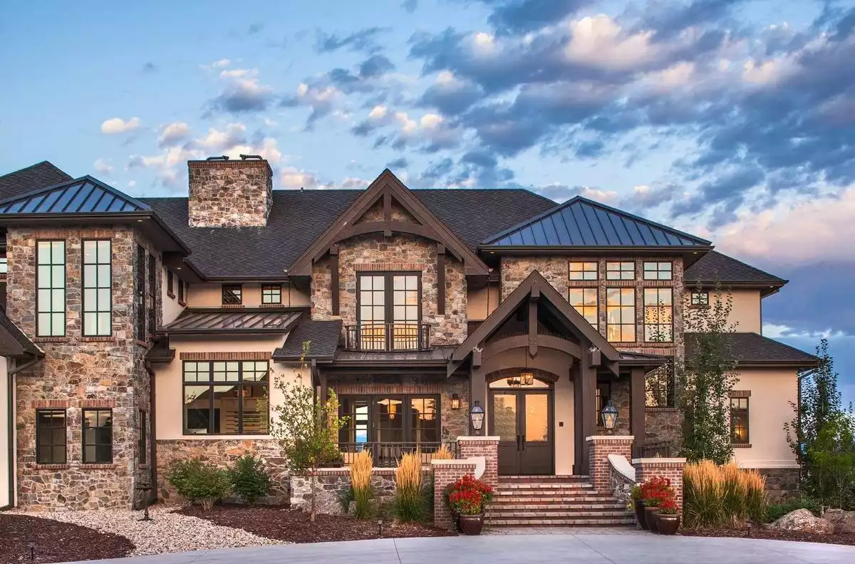 Grand Stone and Stucco Facade with Illuminated Windows and Metal Roofing