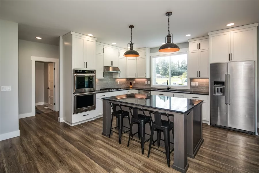 Kitchen with White Shaker Cabinets and Black Granite Island