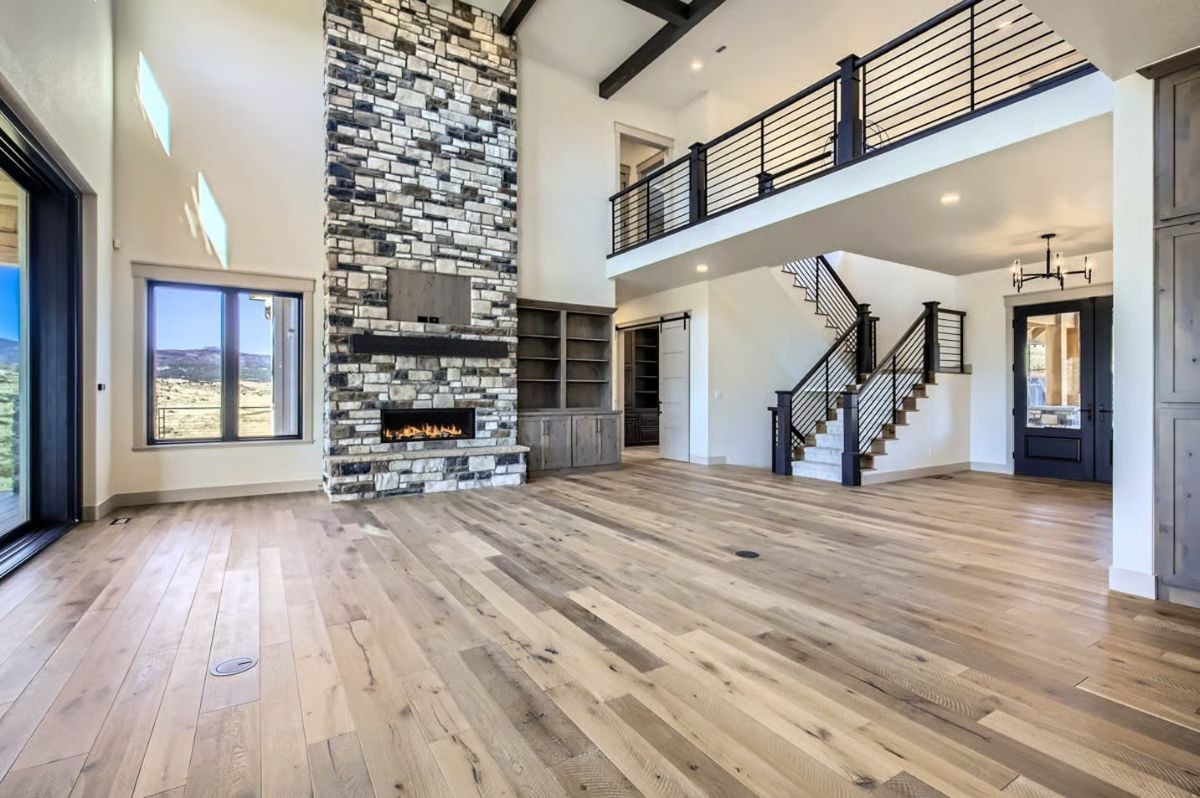 Two-Story Great Room with Stacked Stone Fireplace and Modern Railings