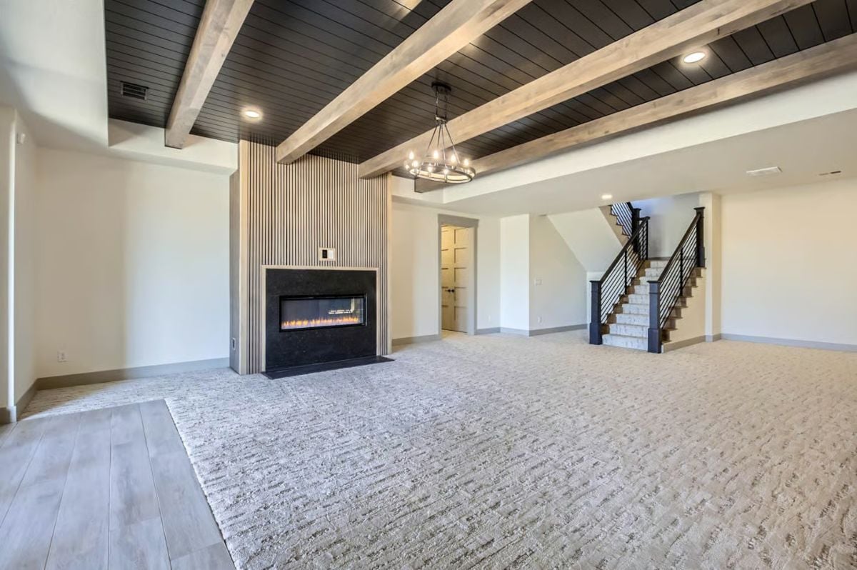 Expansive Basement Recreation Room with Exposed Beam Ceiling