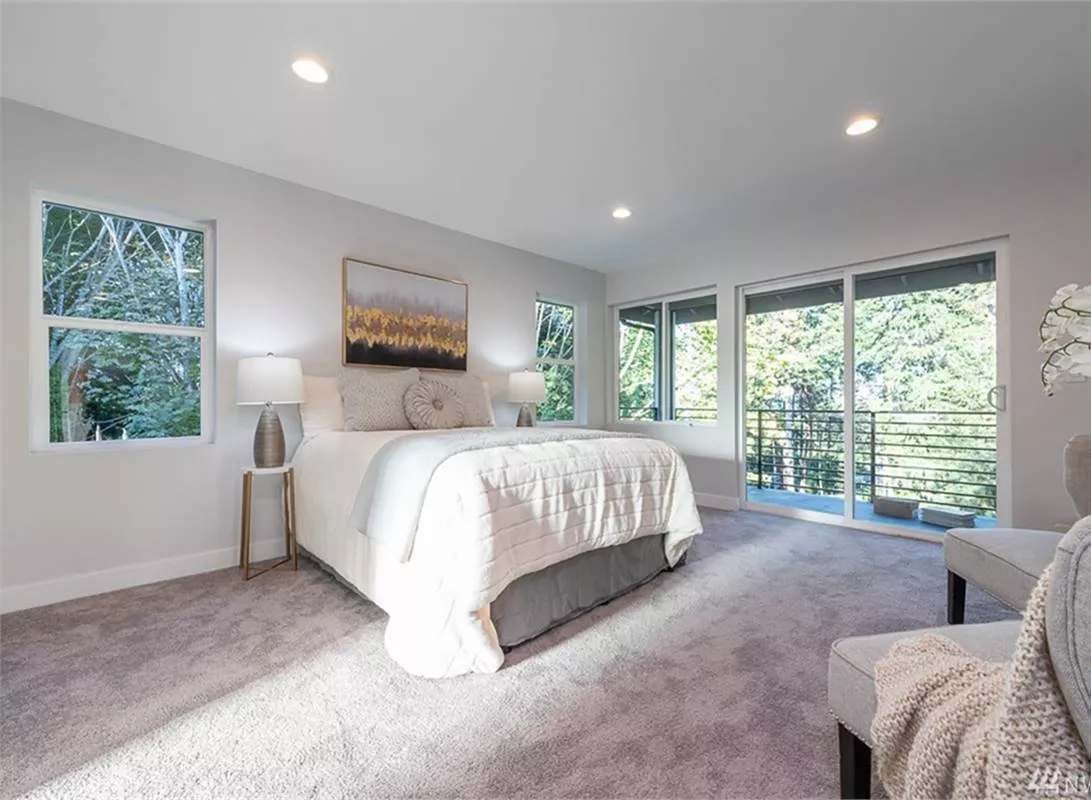 White Bedding and Gray Carpet Create a Calm Base for the Treetop Views