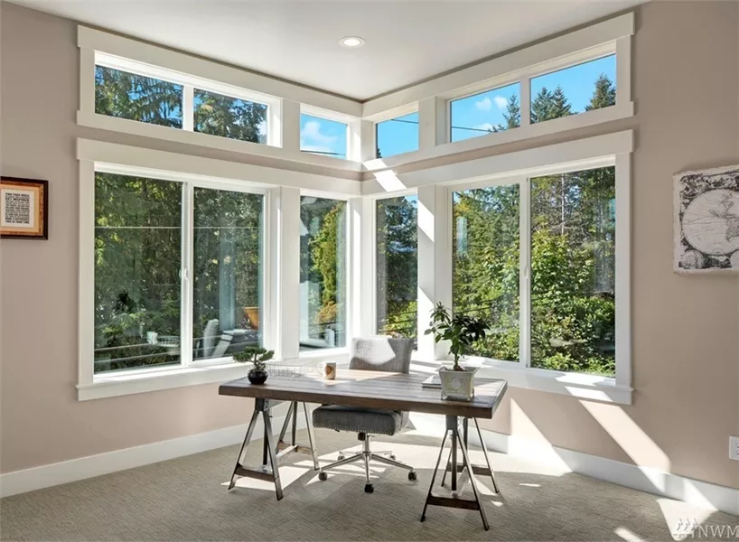 Sunlit Home Office with Floor-to-Ceiling Windows and Simple Desk Setup