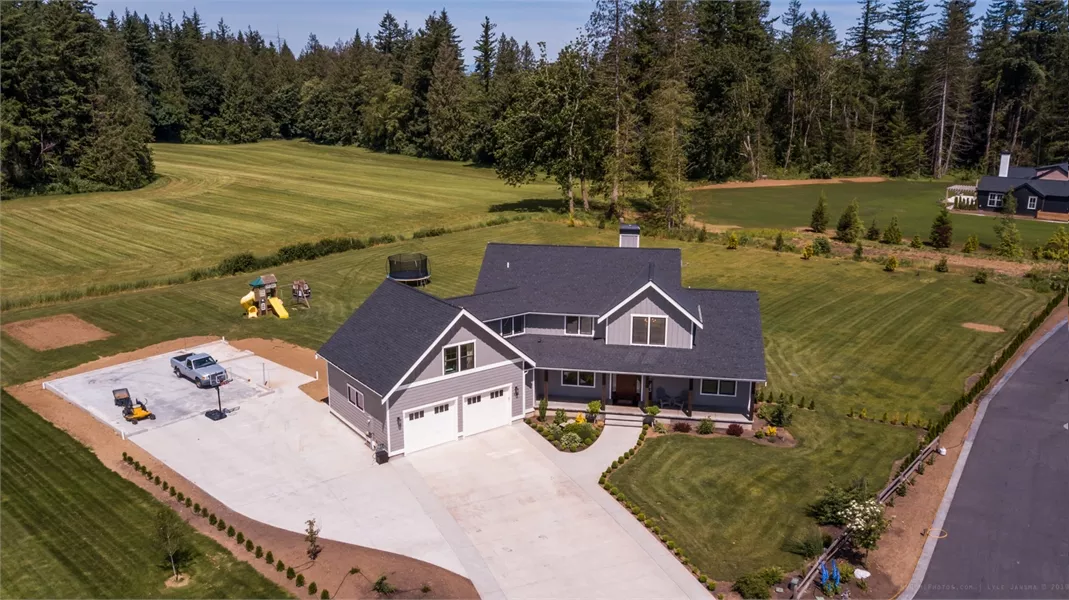 Aerial View of Country Home with Wraparound Driveway and Acreage