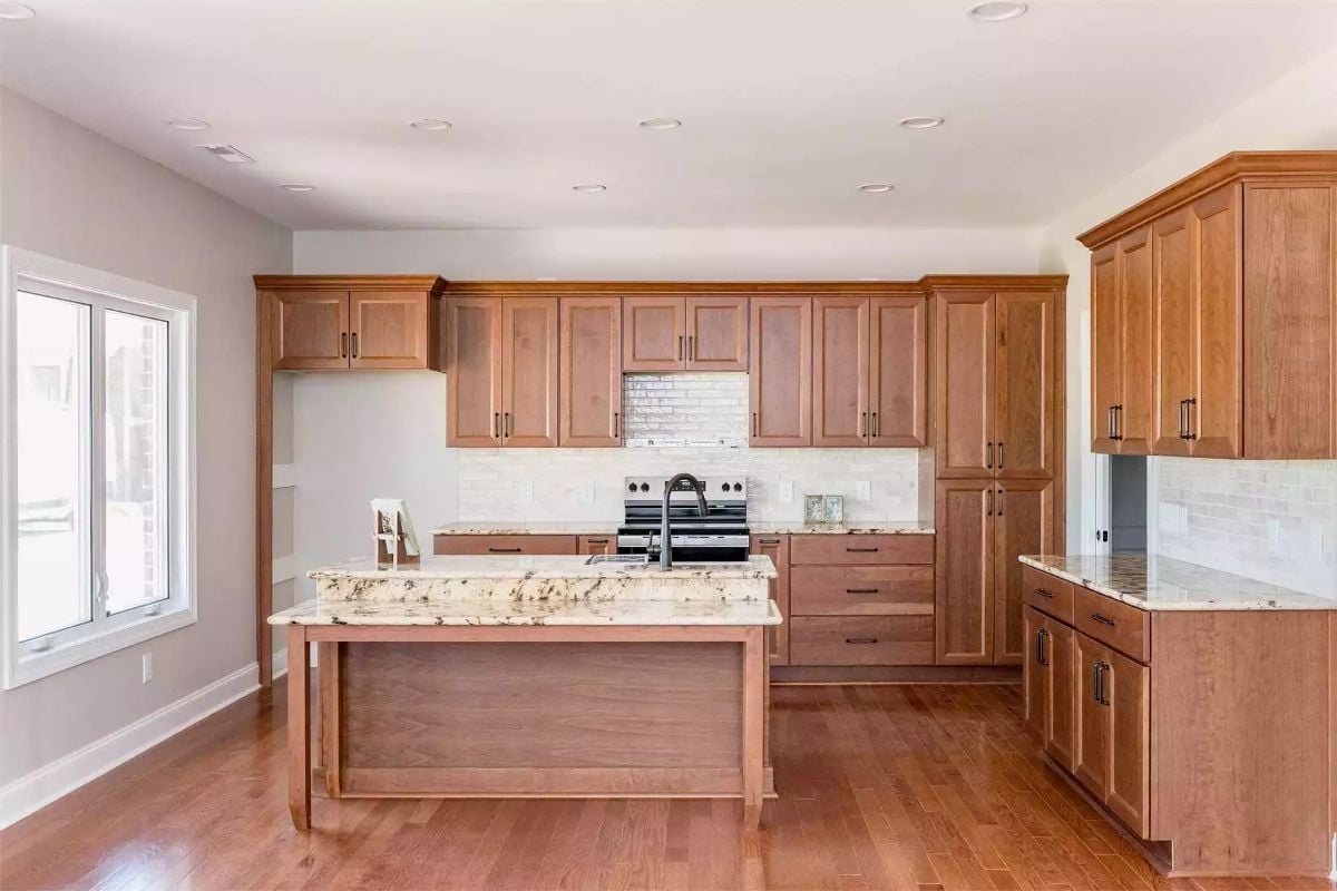 Natural Wood Cabinetry and Granite Island Anchor a Warm Kitchen