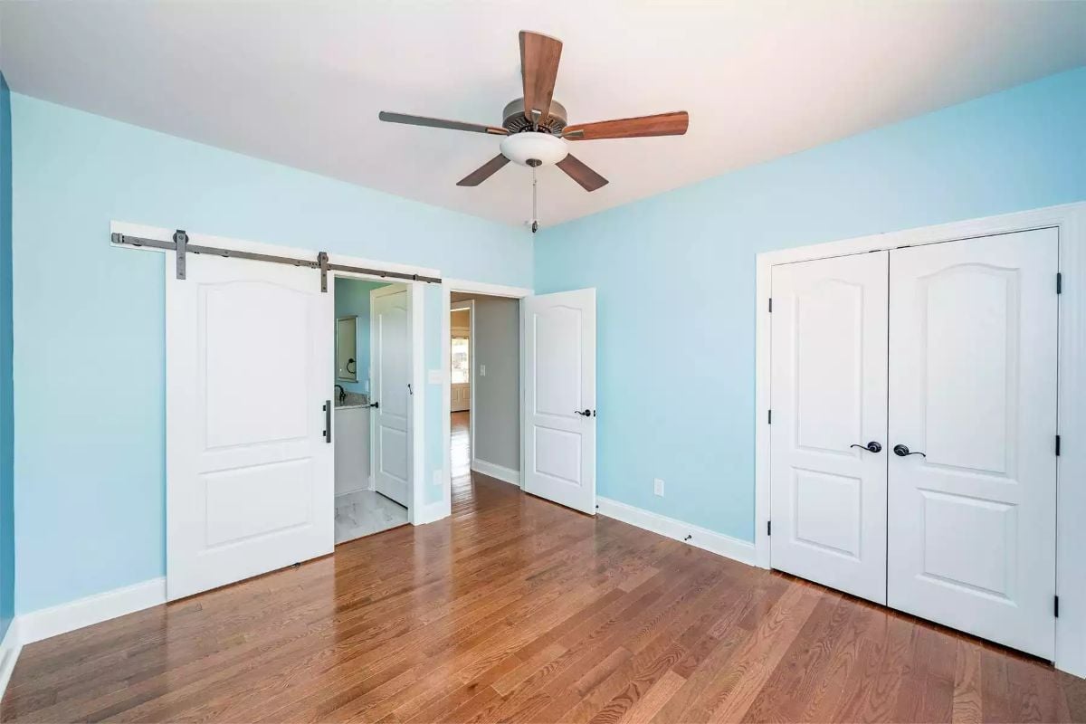 Light Blue Walls Frame Three White Doors in a Bright Bedroom