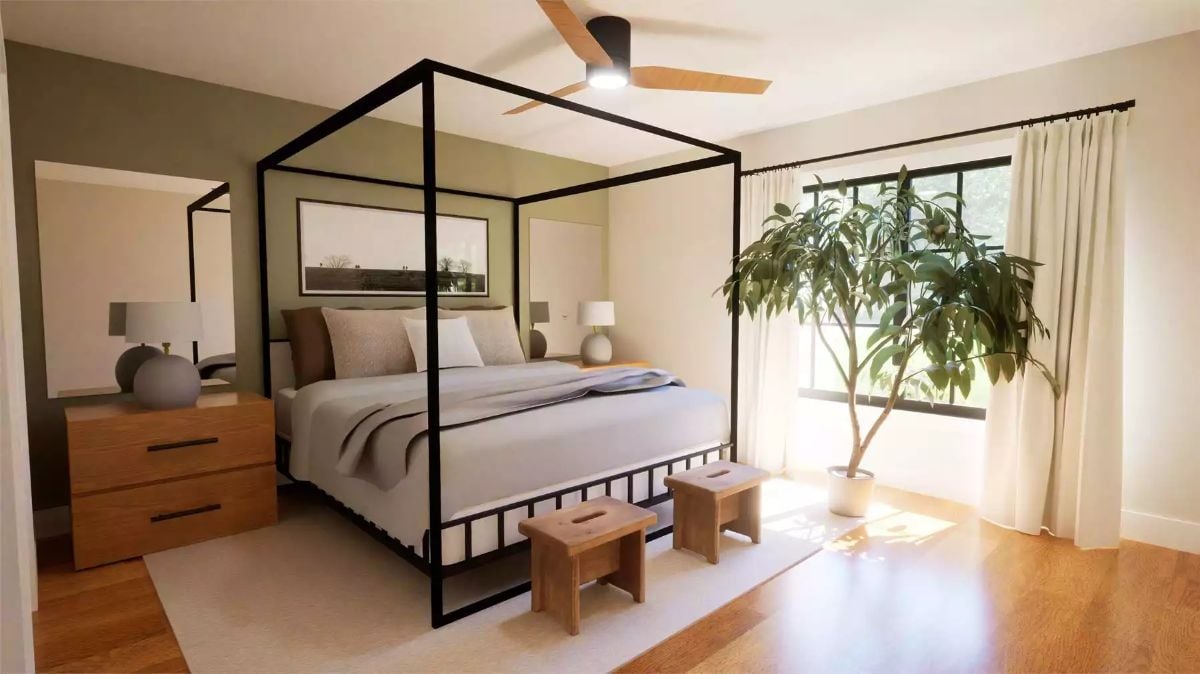 Canopy Bed Framed in Black Metal with Natural Light and Indoor Greenery