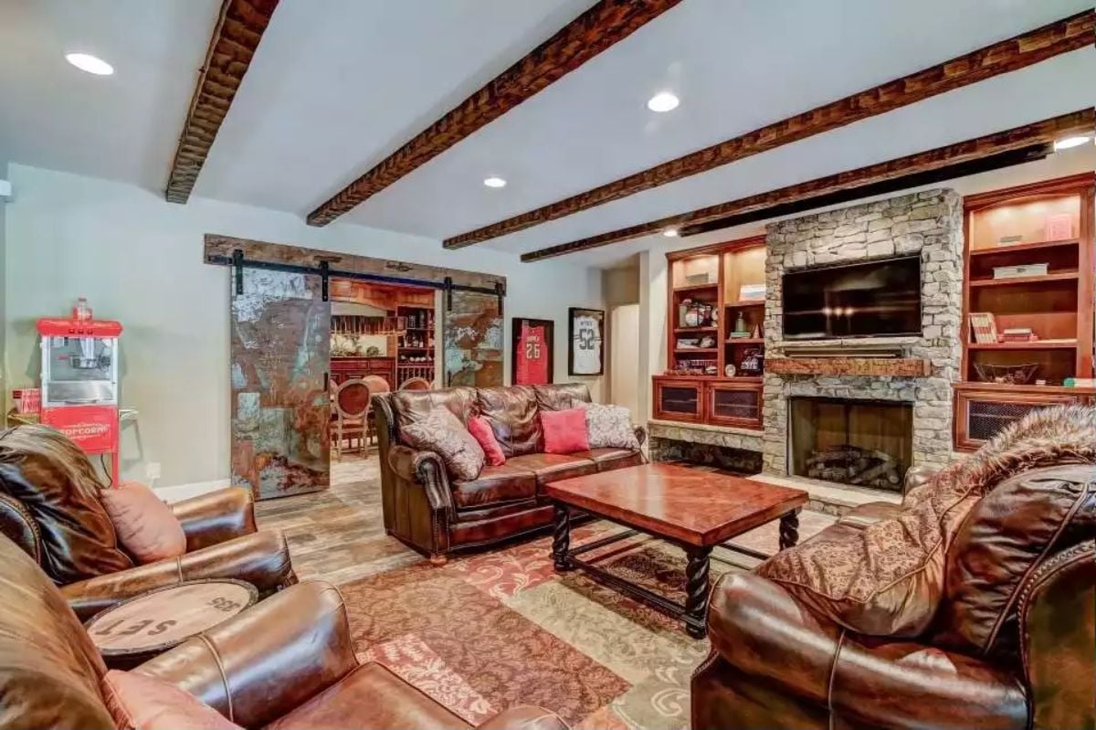 Exposed Wood Beams Frame Entertainment Space with Stone Fireplace