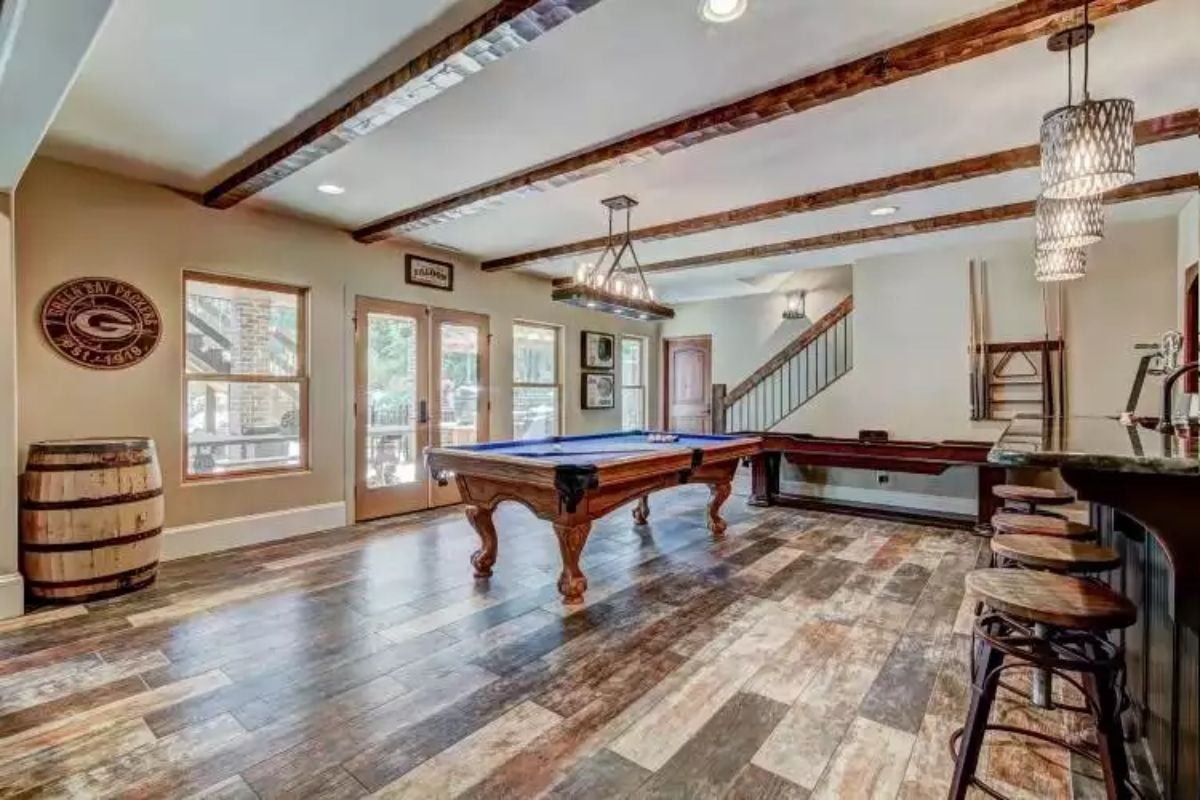 Game Room with Exposed Beams and Pool Table Under Vaulted White Ceiling