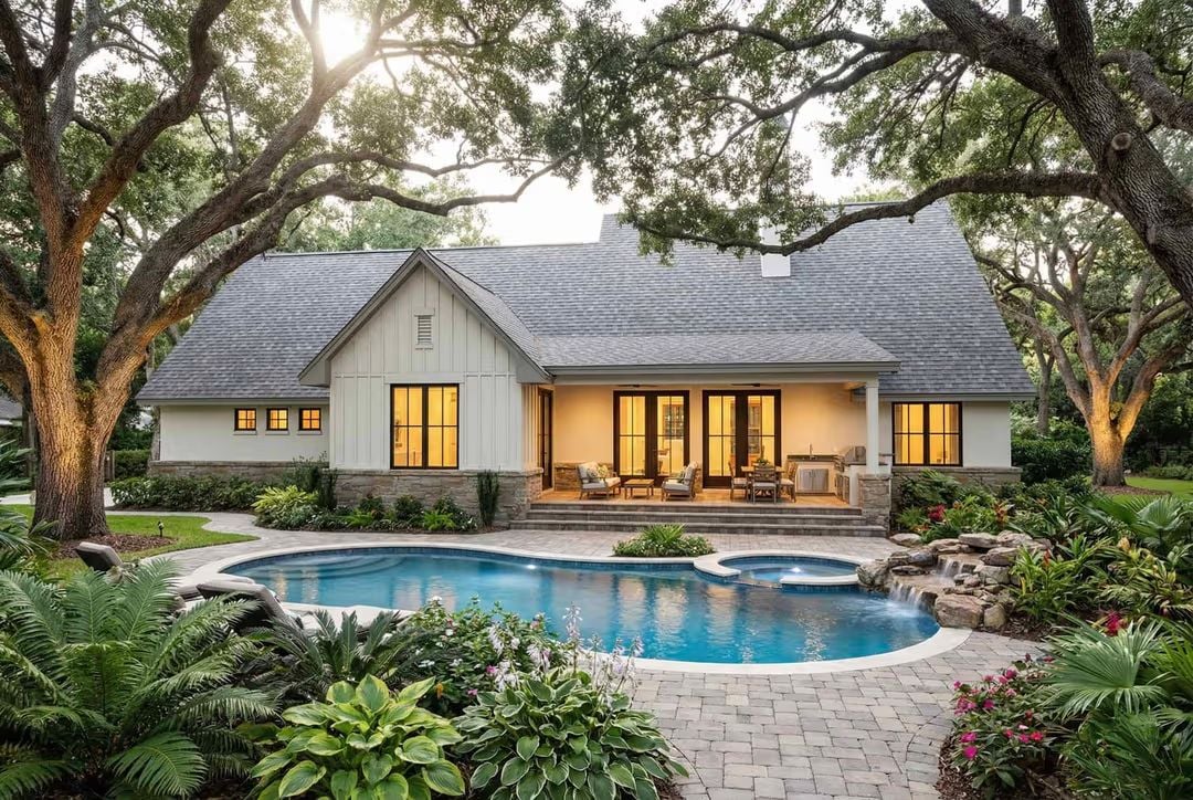 Poolside Living Framed by Mature Oaks and Warm Interior Light