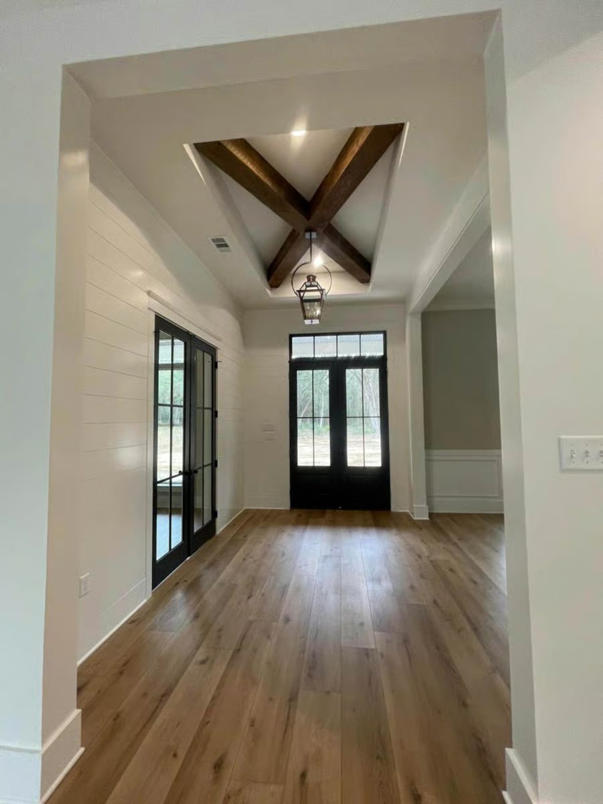 Entryway with Crossed Beam Ceiling Detail and Shiplap Walls