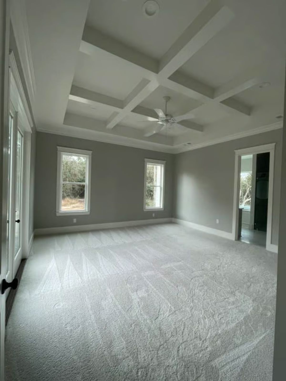 Primary Bedroom with Coffered Ceiling and Plush Carpet