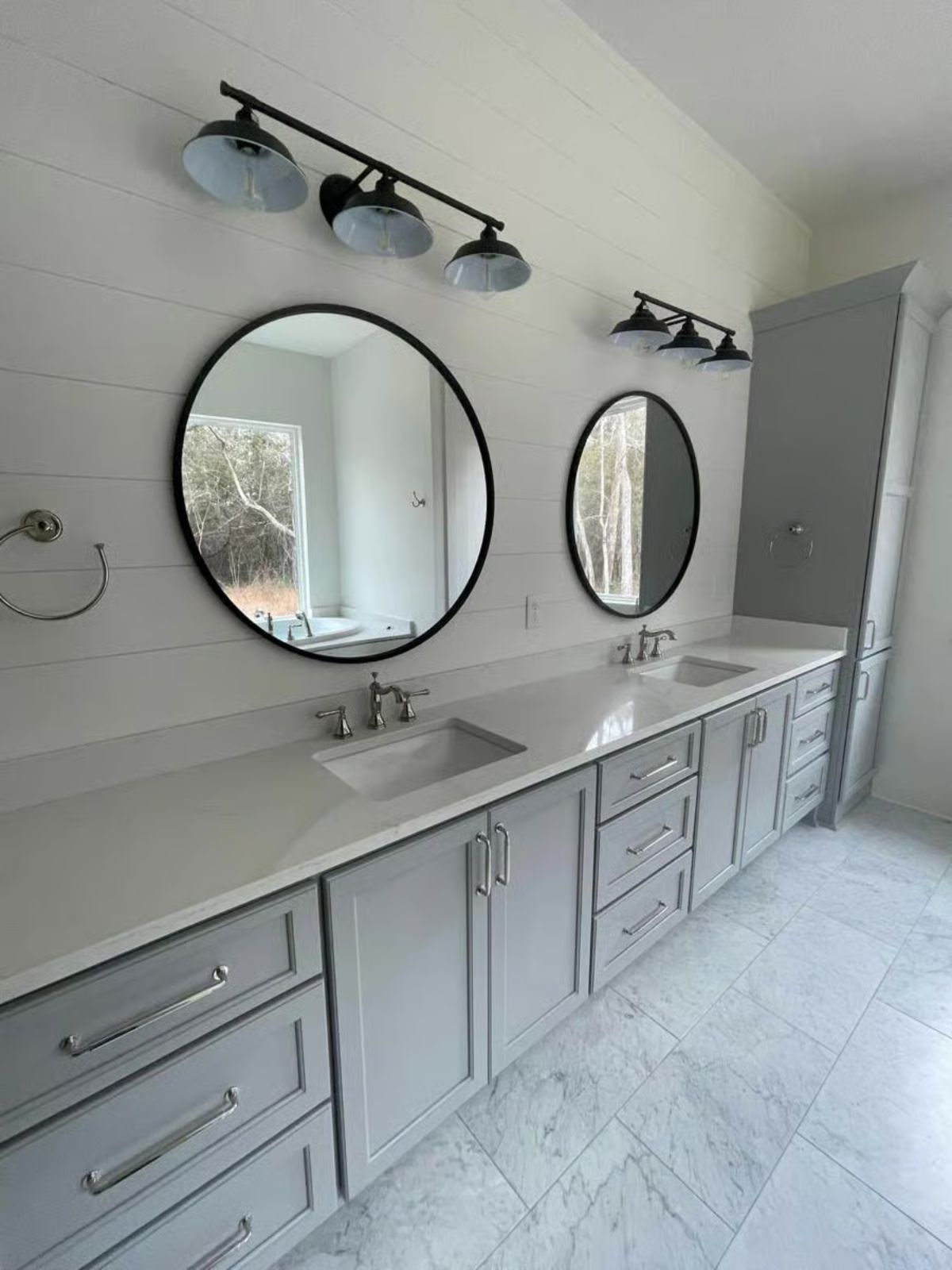 Double Vanity Bathroom with Round Black Mirrors and Shiplap Accent Wall