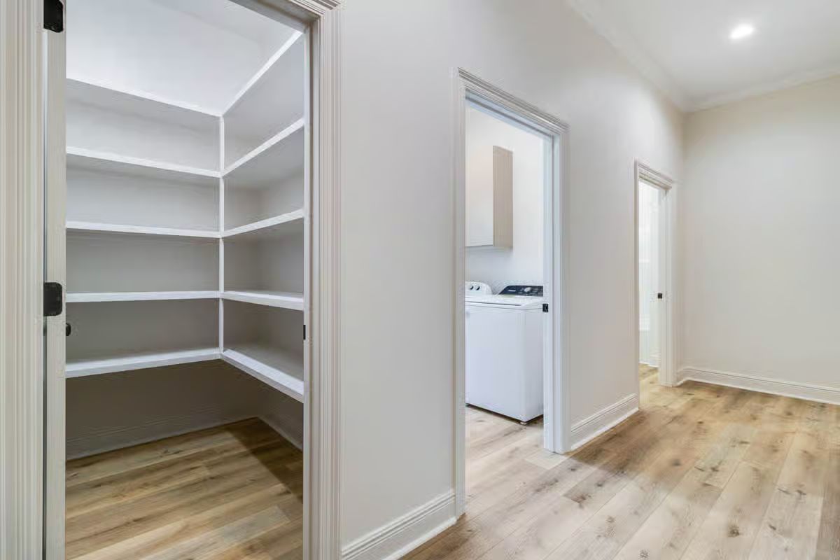 Hallway with Built-In Pantry and Separate Laundry Room Access