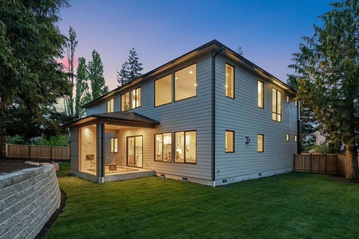 Covered Patio Glows Against a Dusk Sky in This Contemporary Two-Story