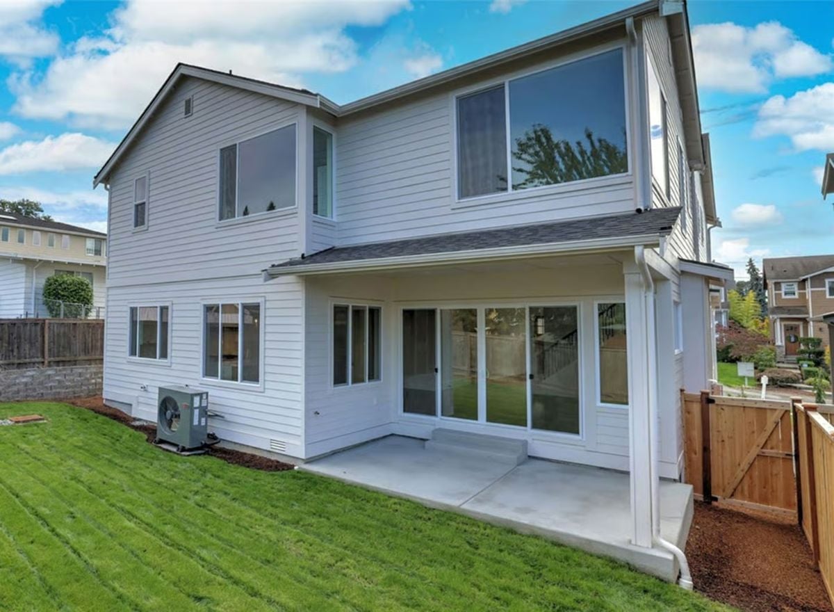 Covered Patio and Clean White Siding Define This Backyard Elevation