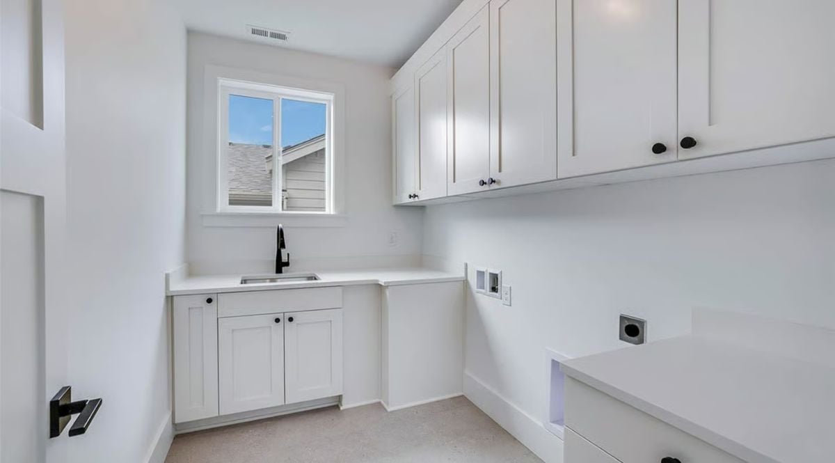 Black Fixtures and Shaker Cabinets Keep This Laundry Room Functional