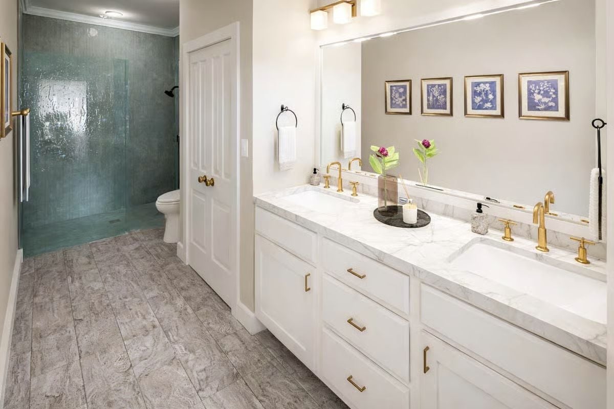 Gold Fixtures and Marble Countertops Set the Tone in the Primary Bath
