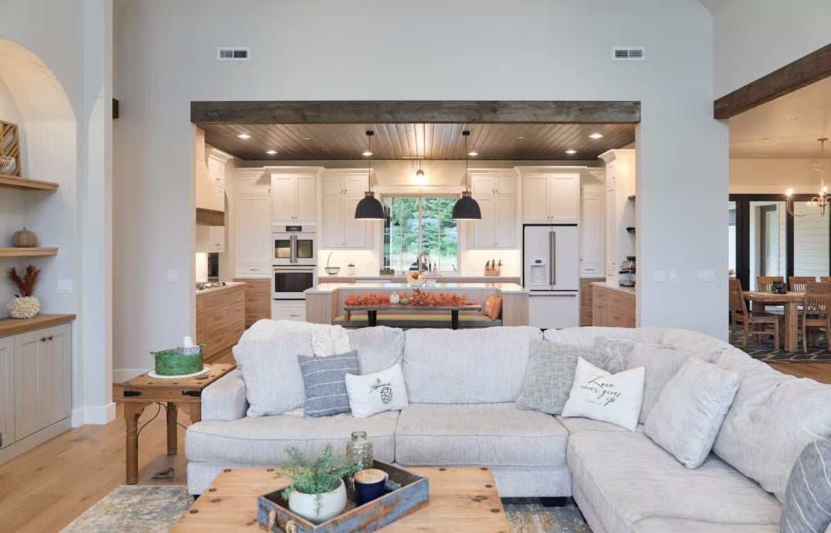 Open Concept Living Space with Wood Beam Portal and Kitchen Views