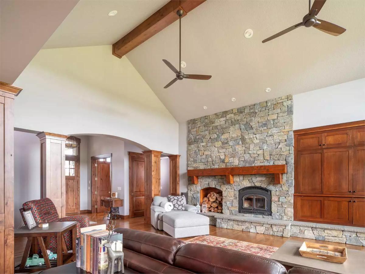 Vaulted Stone Fireplace Anchors a Craftsman Living Room with Exposed Beams