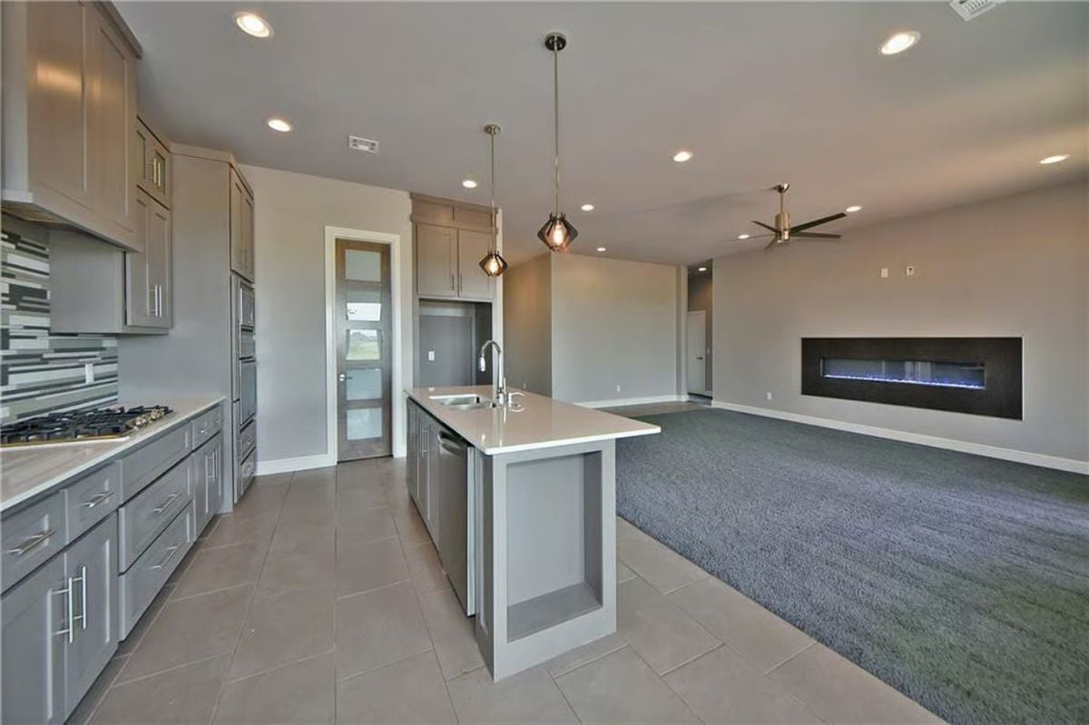 Gray Cabinetry and a Linear Fireplace Define This Open-Concept Kitchen and Living Space