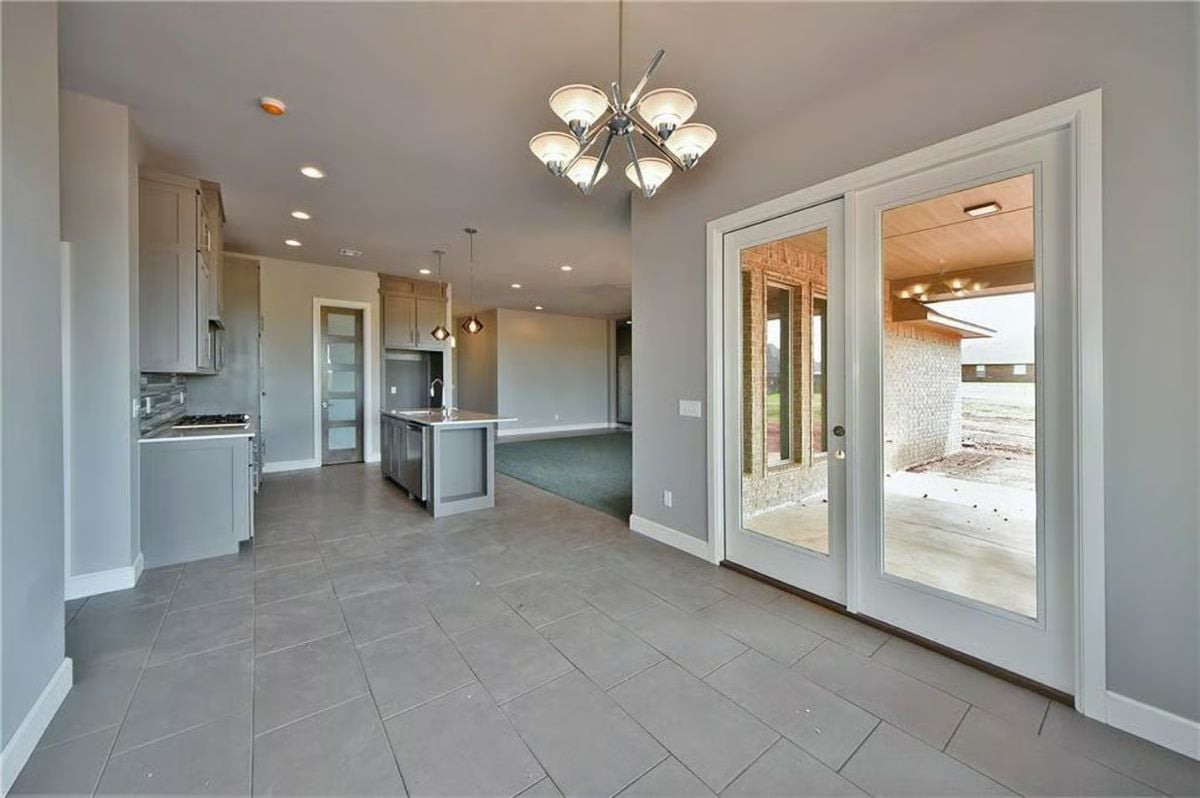 French Doors, Pendant Lights, and Open Sightlines Connect Dining and Kitchen Zones