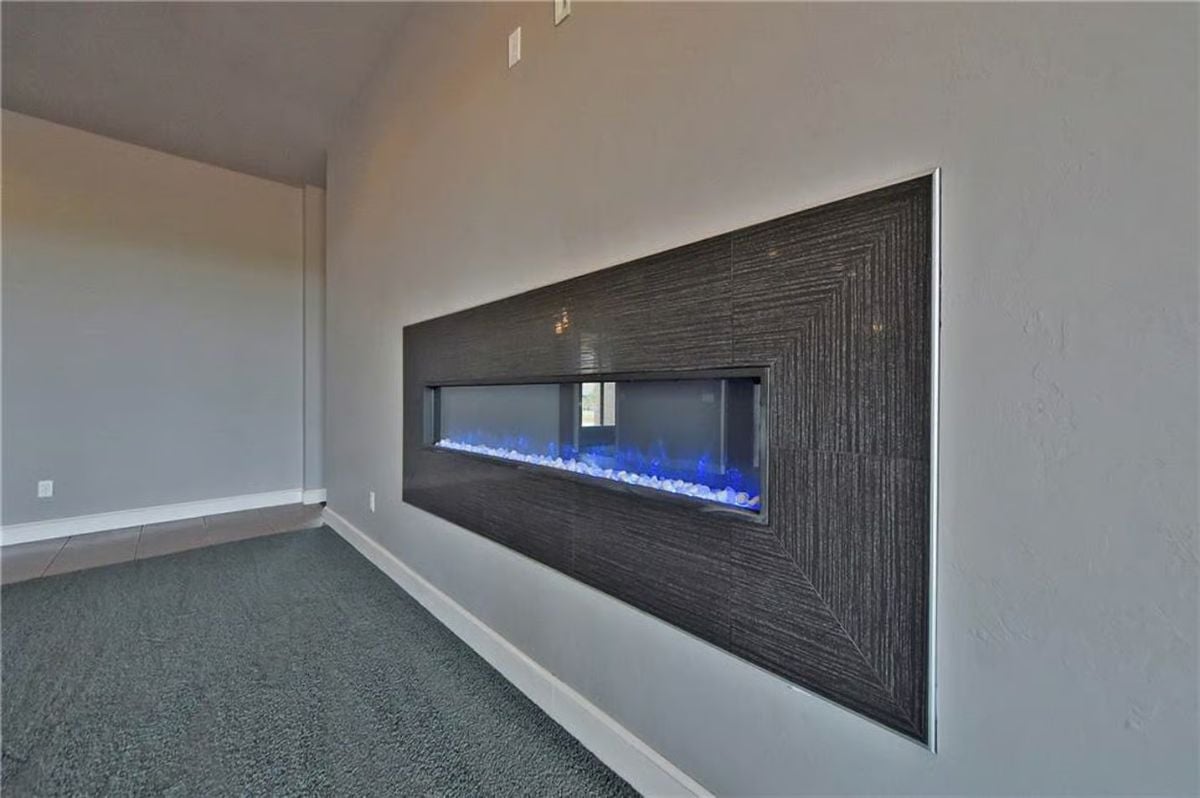 Blue-Lit Electric Fireplace Anchors a Dark Tile Surround in the Living Room