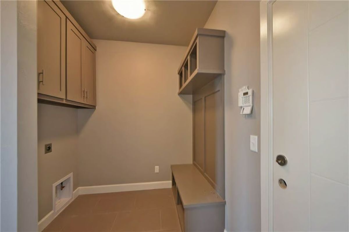 Mudroom Cubbies and Upper Cabinets Keep Gear Organized Near the Entry Door