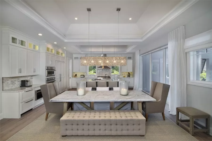 Marble Tabletop, Tufted Bench, and Crystal Pendant Light Define This Dining Space