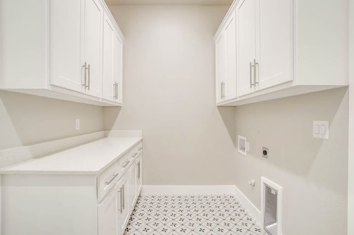 Laundry Room with White Cabinetry and Patterned Tile Flooring